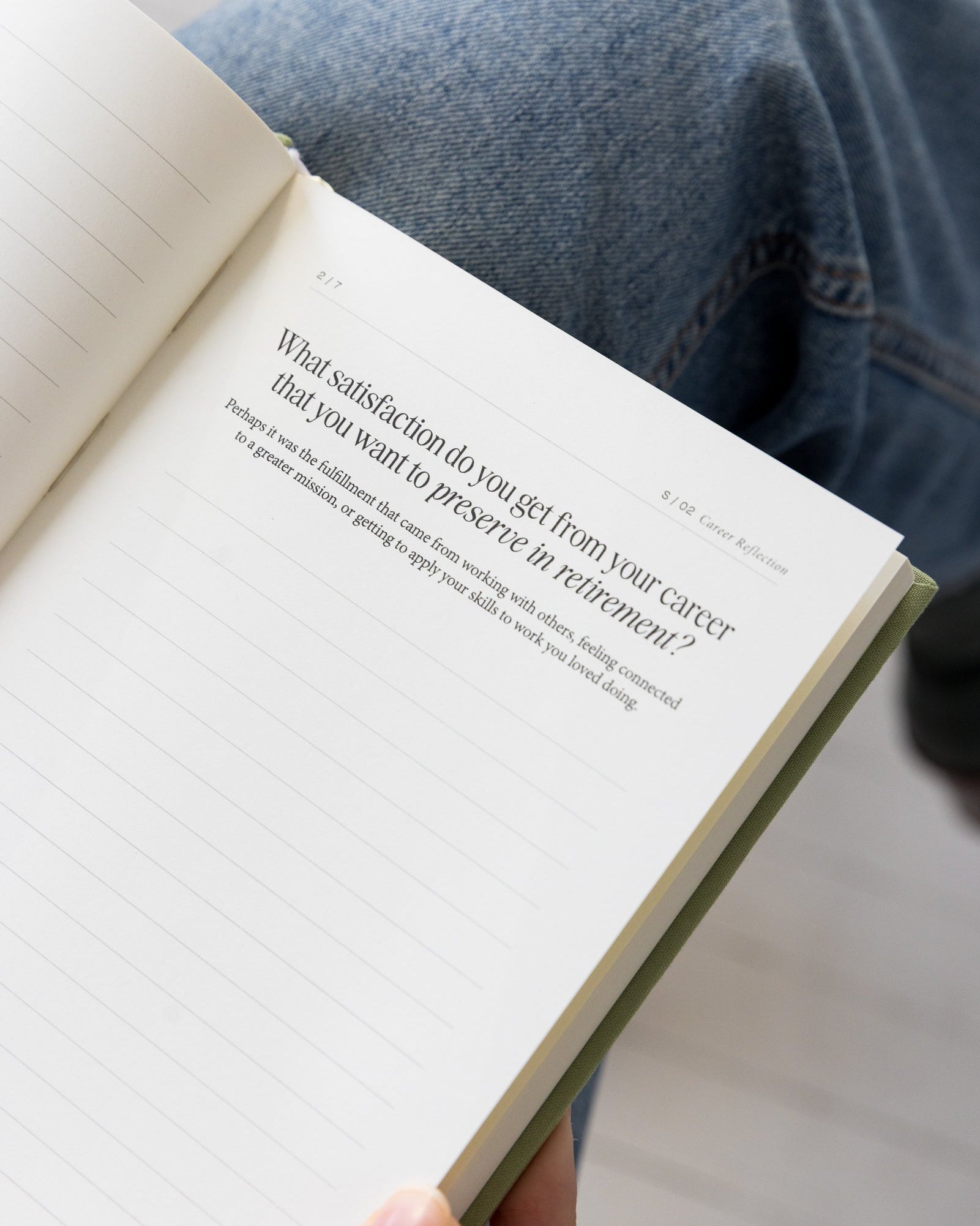 Opened The Anti Retirement Plan with text held by a person, with jeans in the background