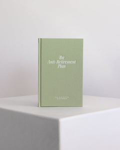 Green guided journal titled 'The Anti-Retirement Plan' on a white surface with a light gray background