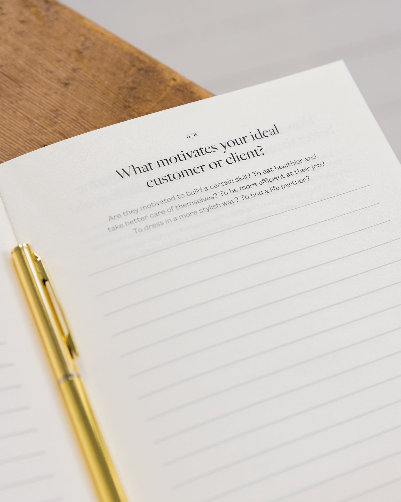 Bedside Business Plan with a pen on a wooden surface, asking about motivations for ideal customer or client.