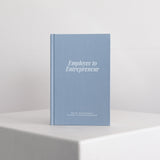 Blue guided journal titled 'Employee to Entrepreneur' on a white surface with a light gray background